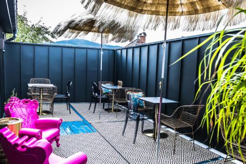 a patio with tables and chairs and an umbrella at Boutique Hotel Massimos in Námestovo