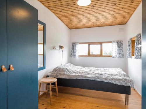 ファーンにあるHoliday home Fanø CXCの木製の天井が特徴のベッドルーム1室(ベッド1台付)
