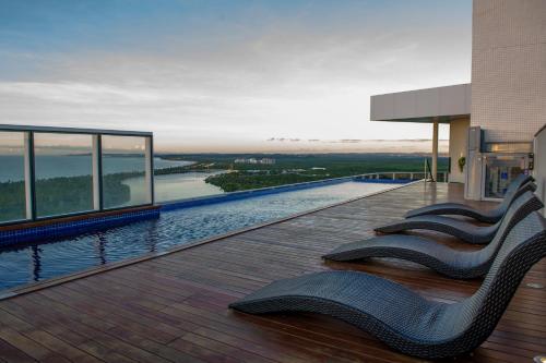 ein Gebäude mit einer Terrasse mit Stühlen darauf in der Unterkunft Silverton Paiva Experience - Flat in Recife