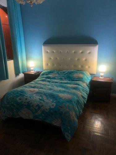 a bedroom with a bed and two lamps on tables at varesse house in Mar del Plata