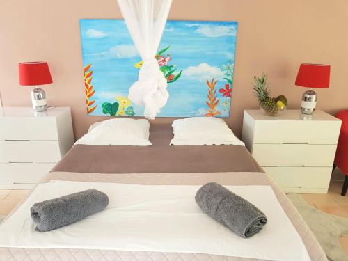 a bedroom with a bed with two pillows on it at Dlo Coco in Les Abymes