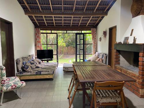 a living room with a wooden table and a fireplace at Solar das Mangueiras - Vale do Capão in Vale do Capao