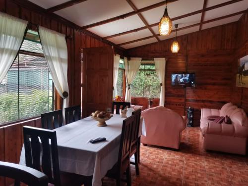 comedor con mesa y sofá en Casa de campo Perlas del Río, en Cartago