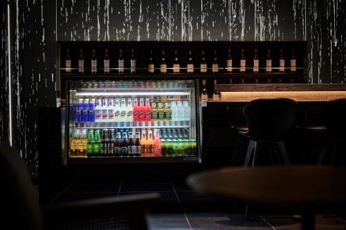 a refrigerator full of drinks in a bar at The Royal Park Canvas - Kyoto Nijo in Kyoto