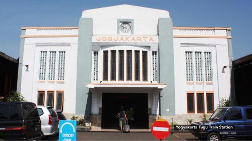 a large white building with a clock on it at S5 Guest House Yogyakarta in Yogyakarta