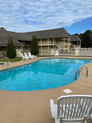 a large swimming pool with chairs and a house at Riverwood Inn in Glenwood