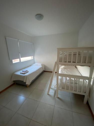 1 dormitorio con 2 literas y suelo de baldosa en EDIFICIO CORAL 2 Dormitorio Y EDIFICIO ARENAS 1 Dormitorio en Puerto Madryn