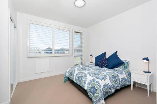 a white bedroom with a bed and a window at Ocean Views 41 in Anna Bay