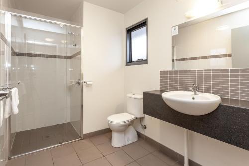uma casa de banho com um WC, um lavatório e um chuveiro em Kingston hotel Motel em Kingston