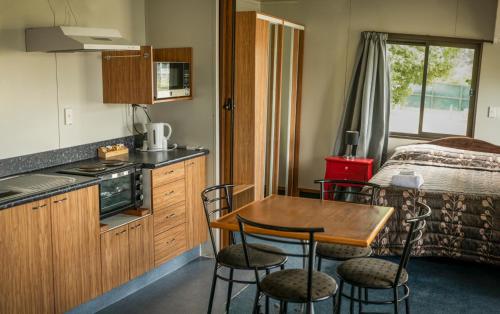 FernsideにあるRangiora Eco Holiday Parkのキッチン(テーブル、椅子付)