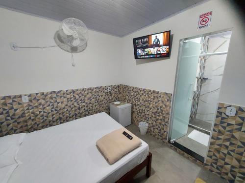 una camera con letto e doccia con ventilatore di Pousada do Leô a Mangaratiba