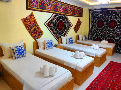 a room with two beds and a red carpet at Samarkand Сity Guest House in Samarkand