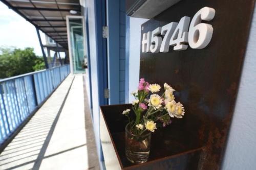 a vase of flowers sitting on a ledge on a building at Chanchalay Hip Hostel SHA Extra Plus in Krabi town