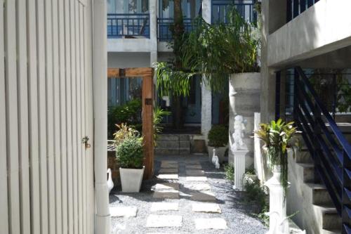 a courtyard with potted plants in front of a building at Chanchalay Hip Hostel SHA Extra Plus in Krabi town
