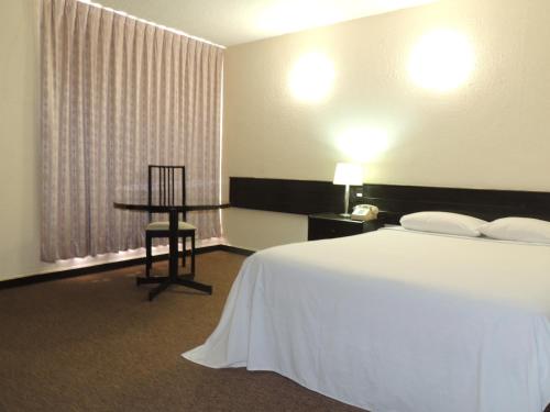 Säng eller sängar i ett rum på Hotel Lizbeth