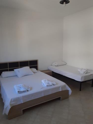 2 camas en una habitación con paredes blancas en Sunset House Aurora&Ersi, en Orikum