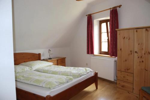 um quarto com uma cama e uma janela em Hof Grünfelder em Friedersdorf