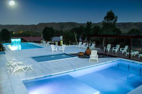 a pool with chairs and a table at Complejo el Paine in Villa General Belgrano