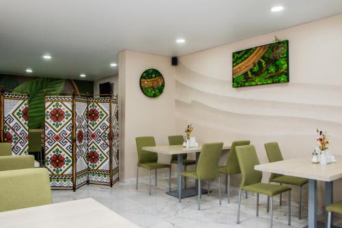 a restaurant with white tables and green chairs at Гостинний двір "Марія" in Kropyvnytskyi