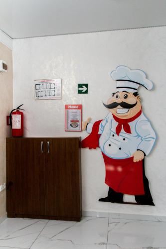a mural of a chef painted on a wall at Гостинний двір "Марія" in Kropyvnytskyi