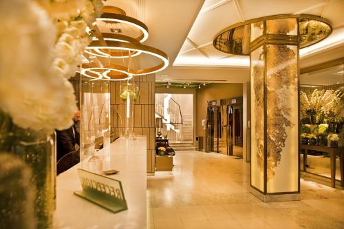 a lobby of a fashion store with flowers and mirrors at Preciados in Madrid