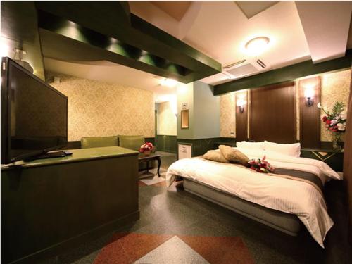 a bedroom with a bed and a flat screen tv at シーライフリゾートホテル in Ashiya