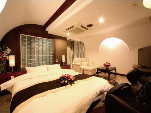 1 dormitorio con 1 cama grande y sala de estar en シーライフリゾートホテル en Ashiya
