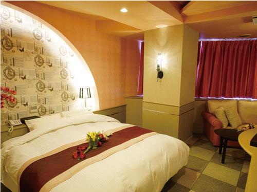 a bedroom with a large bed with flowers on it at シーライフリゾートホテル in Ashiya