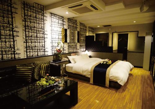 a bedroom with a bed and a living room at シーライフリゾートホテル in Ashiya