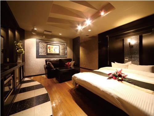 a hotel room with a large bed and a chair at シーライフリゾートホテル in Ashiya