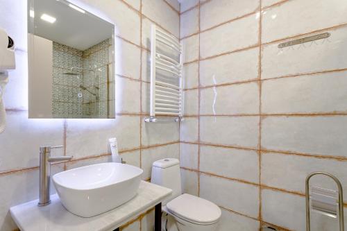 a bathroom with a sink and a toilet and a mirror at Monument1880 in Tbilisi City