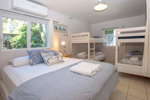 a bedroom with a bed and two bunk beds at Sea Shanties in Amity Point