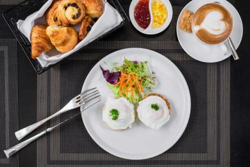 a table with plates of food and a tray of pastries at Palace Gate Hotel & Resort By EHM in Phnom Penh