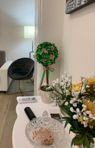 a table with a glass plate and flowers on it at Pompei Luxury Suite in Pompei