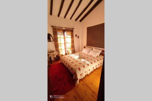 a bedroom with a bed with a comforter at ΑΡΧΟΝΤΙΚΟ ΣΤΟΥΣ ΠΡΟΠΟΔΕΣ ΤΟΥ ΟΡΟΥΣ ΔΙΡΦΥΣ in Loútsa