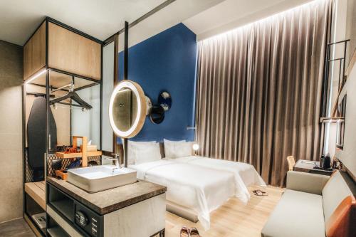 a bedroom with a bed and a sink and a mirror at The Botanica Sanctuary in Puncak