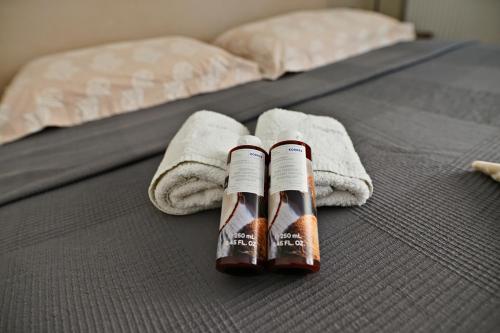 Duas garrafas de café e toalhas numa cama em Cozy Urban Apartment at Agios Dimitrios em Atenas