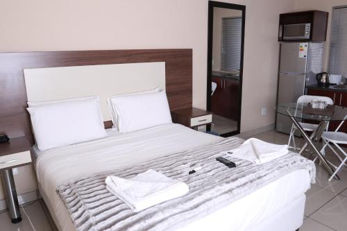 a bedroom with a large bed with towels on it at Eagle Nest Luxury Accommodation in Roodepoort