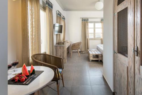 a room with a table and chairs and a living room at Caldera's Dolphin Suites in Megalokhori