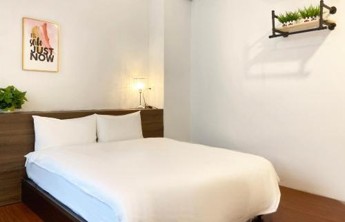 a bedroom with a white bed in a room at 埔里城民宿 PuliTown BNB in Puli
