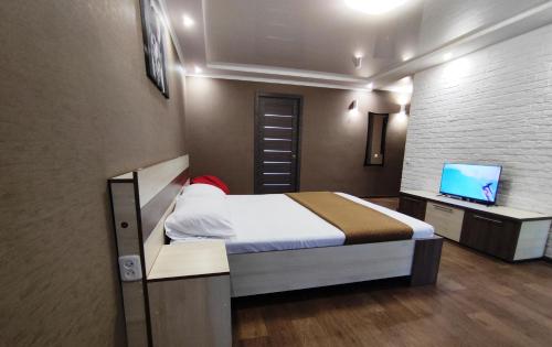 Dormitorio pequeño con cama y TV en Двухкомнатный люкс центр Соборности 29 KR Apartments, en Krivoy Rog