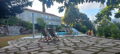 un grupo de sillas sentadas en un patio de piedra en Quinta de Águia - Non-Smoking Property en São Lourenço do Douro