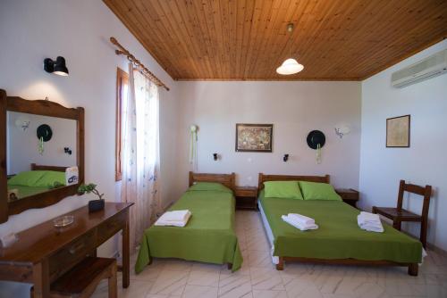 a room with two beds and a wooden ceiling at Ilios Studios in Lefkada
