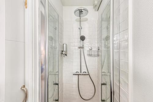 une salle de bain avec une douche avec une porte vitrée dans l'établissement Le Monocle, à Châteauroux