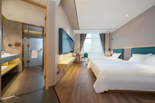 a hotel room with two beds and a bathroom at Chaoman Hotel in Jingzhou