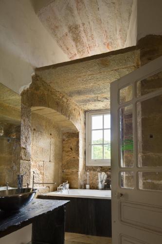 une salle de bain avec un lavabo et une fenêtre dans l'établissement Chateau de Lissac, à Lissac-sur-Couze