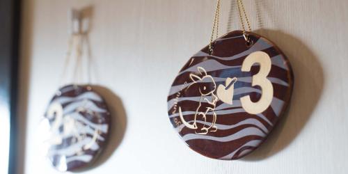 a clock with the number three hanging on a wall at Kyo-Anthu Inn in Kyoto