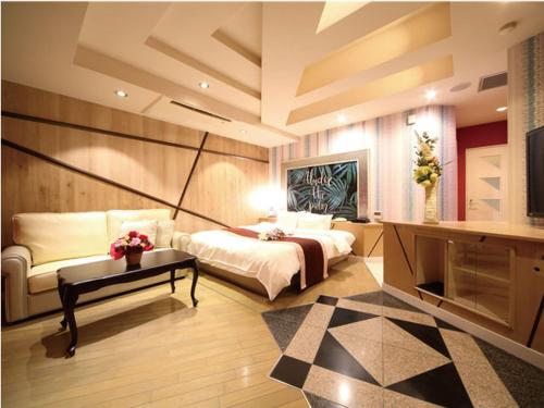 a large bedroom with a bed and a table at シーライフリゾートホテル in Ashiya