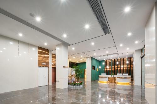 un hall de bureau avec un grand plafond en verre dans l'établissement Chaoman Hotel, à Jingzhou