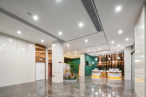 an office lobby with a large glass ceiling at Chaoman Hotel in Jingzhou
